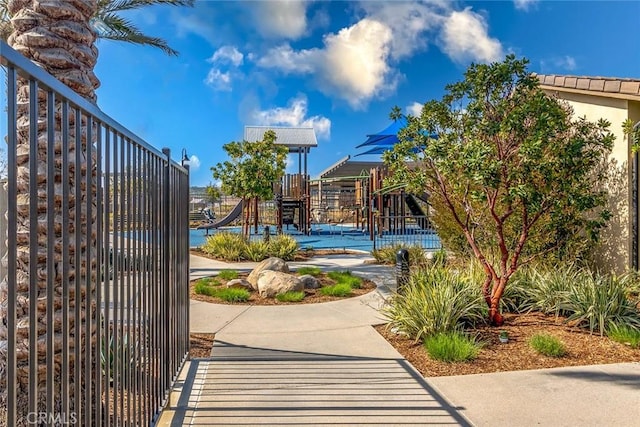 view of community featuring fence and playground community