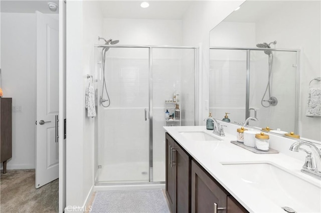 full bath featuring double vanity, a sink, and a stall shower