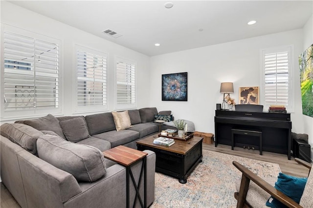 living area with recessed lighting, visible vents, and light wood-style flooring