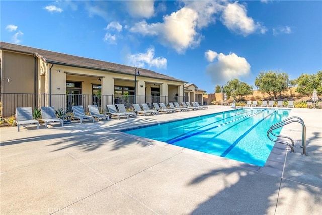 pool featuring fence and a patio area