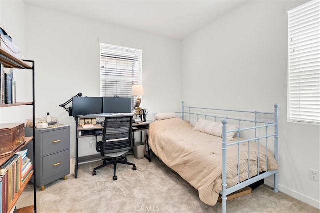 bedroom with baseboards and light carpet