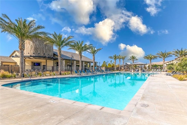 pool with a patio and fence