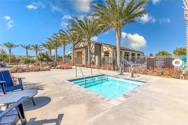 view of pool with a patio area and fence