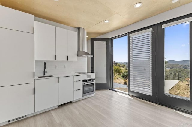 68256827 Kellyn Ln, Vista, CA 92084 - kitchen featuring wall chimney range hood, a sink, light countertops, stainless steel oven, and recessed lighting