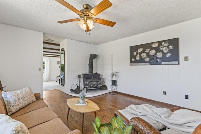 68256827 Kellyn Ln, Vista, CA 92084 - living area featuring a ceiling fan, a wood stove, a textured ceiling, and wood finished floors