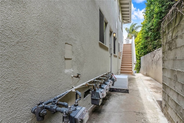 view of home's exterior featuring a patio, fence, stairs, and stucco siding