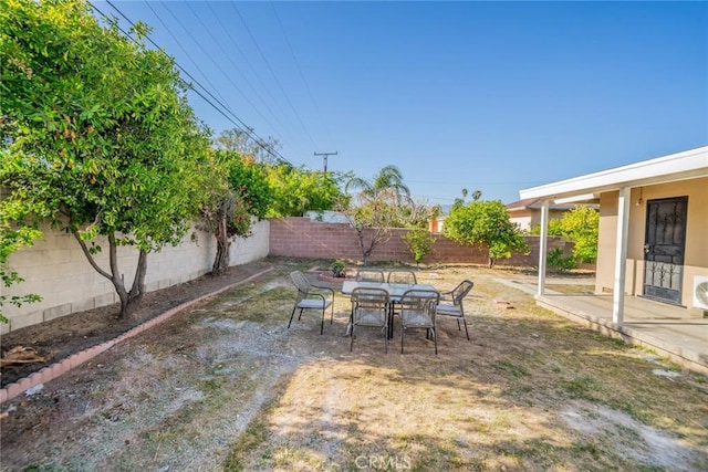 view of yard with outdoor dining area, a fenced backyard, and a patio area