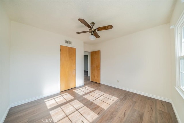 unfurnished bedroom featuring baseboards, visible vents, and light wood-style flooring