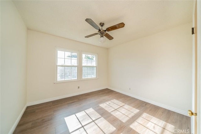 empty room featuring baseboards, ceiling fan, and wood finished floors