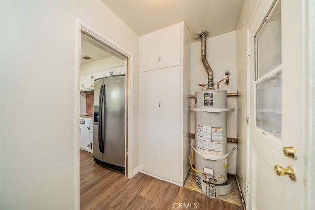 utility room featuring visible vents and water heater