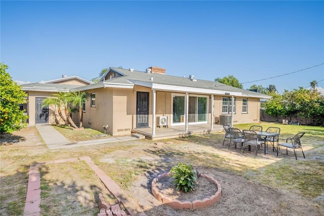back of house featuring a lawn, fence, and stucco siding
