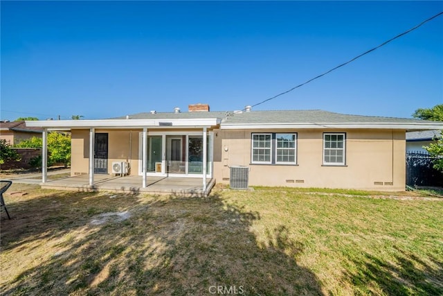 back of property with crawl space, a chimney, a patio area, central air condition unit, and a yard