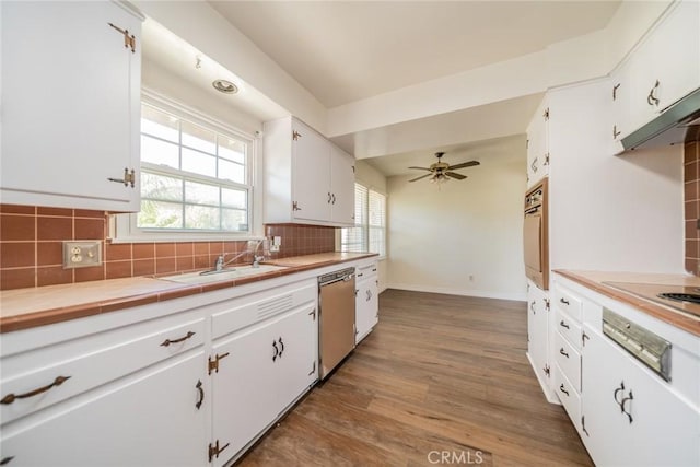 kitchen featuring electric cooktop, white cabinets, backsplash, and dishwasher