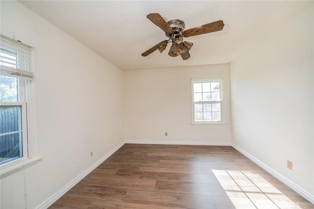 unfurnished room with baseboards, a ceiling fan, and wood finished floors