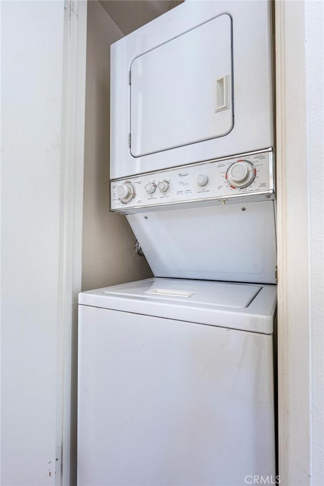 washroom with laundry area and stacked washer / dryer