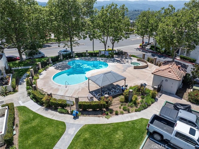 view of swimming pool with a lawn and a mountain view