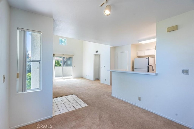unfurnished living room featuring a sink and carpet floors