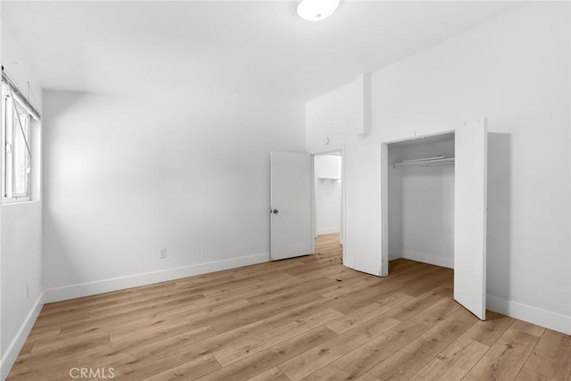 unfurnished bedroom featuring baseboards, a closet, and light wood finished floors