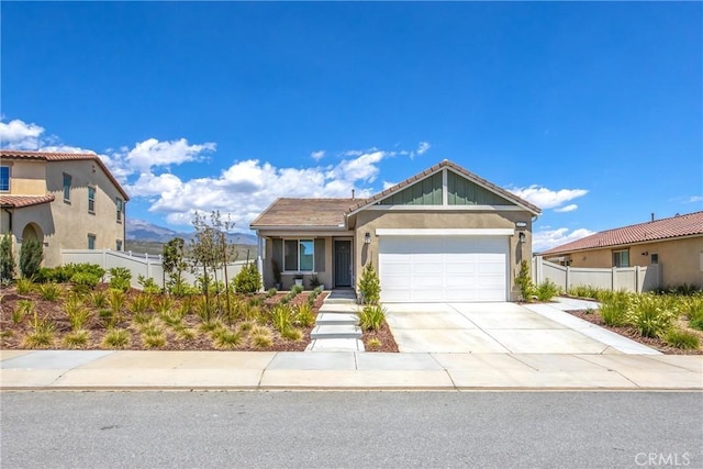 view of front of property with a garage, fence, a tiled roof, and concrete driveway