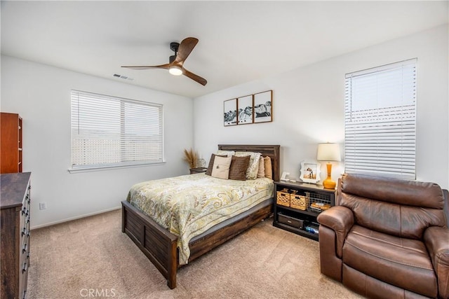 bedroom with a ceiling fan, baseboards, visible vents, and light carpet
