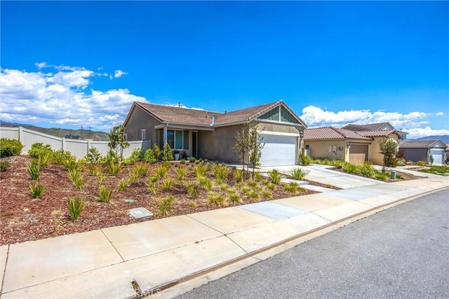 single story home featuring stucco siding, a garage, fence, and concrete driveway