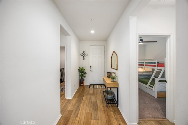 hall with recessed lighting, baseboards, and light wood finished floors