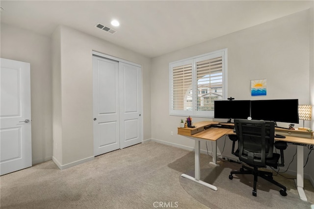 office featuring visible vents, baseboards, and light carpet
