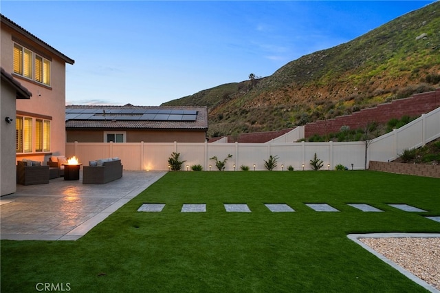view of yard featuring an outdoor living space, a mountain view, a fenced backyard, and a patio area