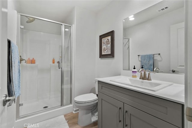 full bathroom featuring a shower stall, toilet, wood finished floors, and visible vents