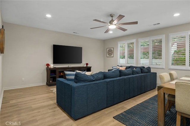 living area with ceiling fan, visible vents, a healthy amount of sunlight, and light wood finished floors