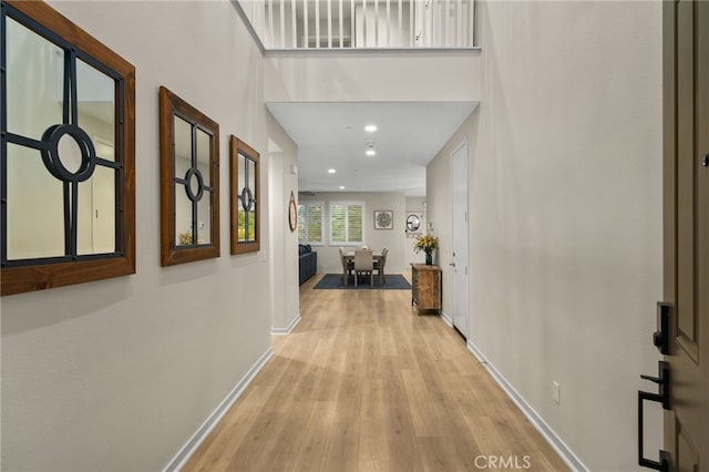 corridor featuring baseboards, recessed lighting, and wood finished floors