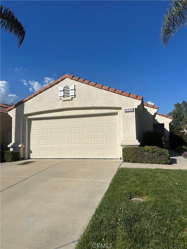mediterranean / spanish-style home featuring a garage, stucco siding, driveway, and a tile roof