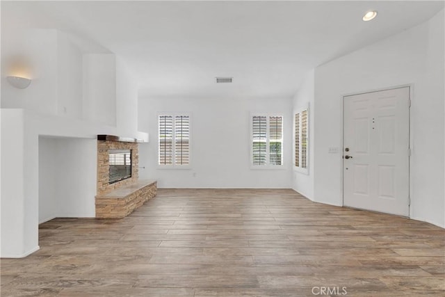 40684 Corte Albara, Murrieta, CA 92562 - unfurnished living room with recessed lighting, visible vents, a stone fireplace, and wood finished floors