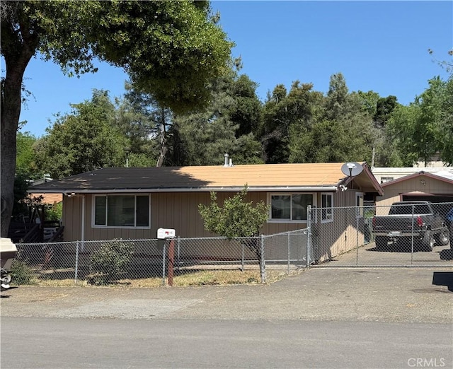 ranch-style house featuring concrete driveway and a fenced front yard