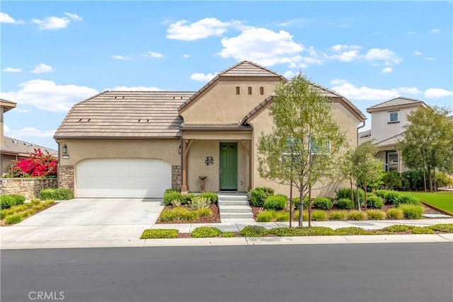 view of front of house featuring a garage, stucco siding, driveway, and a tile roof