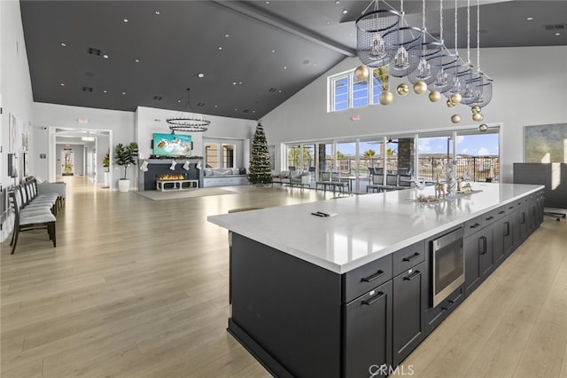 32148 Sedge Way, Temecula, CA 92591 - kitchen featuring high vaulted ceiling, stainless steel microwave, light countertops, a large island, and light wood-style floors