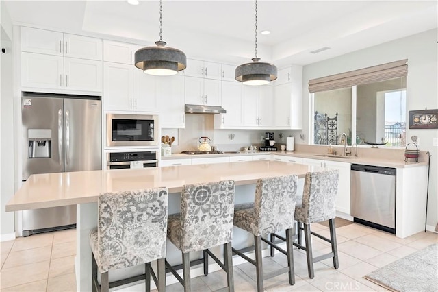 32148 Sedge Way, Temecula, CA 92591 - kitchen featuring appliances with stainless steel finishes, a sink, under cabinet range hood, white cabinets, and a kitchen island