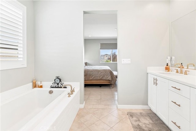 ensuite bathroom featuring tile patterned flooring, ensuite bath, vanity, baseboards, and a bath