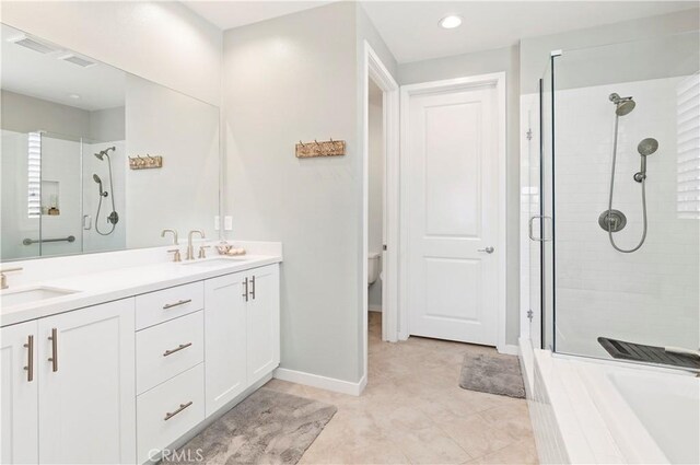 full bathroom with double vanity, baseboards, a sink, and a stall shower