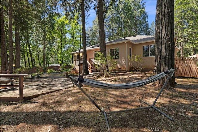 14124 Rollins Ct, Magalia, CA 95954 - exterior space with roof mounted solar panels, stucco siding, a deck, and fence