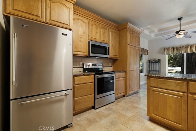 14124 Rollins Ct, Magalia, CA 95954 - kitchen featuring decorative backsplash, dark stone counters, a ceiling fan, and stainless steel appliances