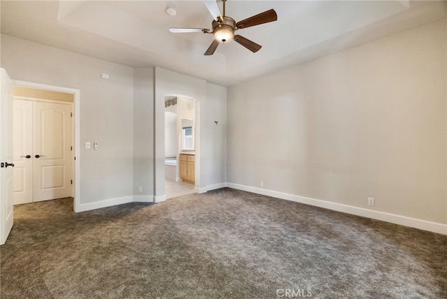 14124 Rollins Ct, Magalia, CA 95954 - unfurnished bedroom featuring baseboards, ceiling fan, connected bathroom, arched walkways, and carpet