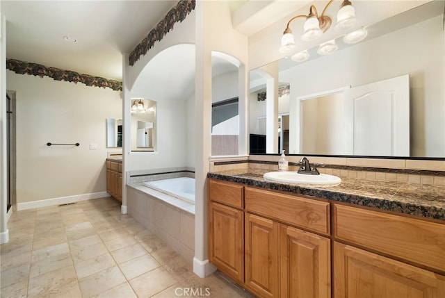 14124 Rollins Ct, Magalia, CA 95954 - bathroom featuring vanity, baseboards, tile patterned floors, and a bath