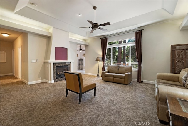14124 Rollins Ct, Magalia, CA 95954 - living area featuring a fireplace, baseboards, ceiling fan, a tray ceiling, and carpet flooring