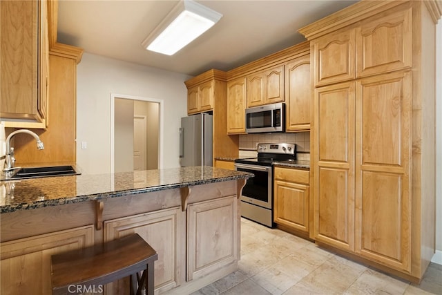 14124 Rollins Ct, Magalia, CA 95954 - kitchen featuring appliances with stainless steel finishes, tasteful backsplash, a sink, a peninsula, and dark stone countertops