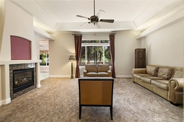 14124 Rollins Ct, Magalia, CA 95954 - carpeted living room with baseboards, a ceiling fan, a glass covered fireplace, and a tray ceiling