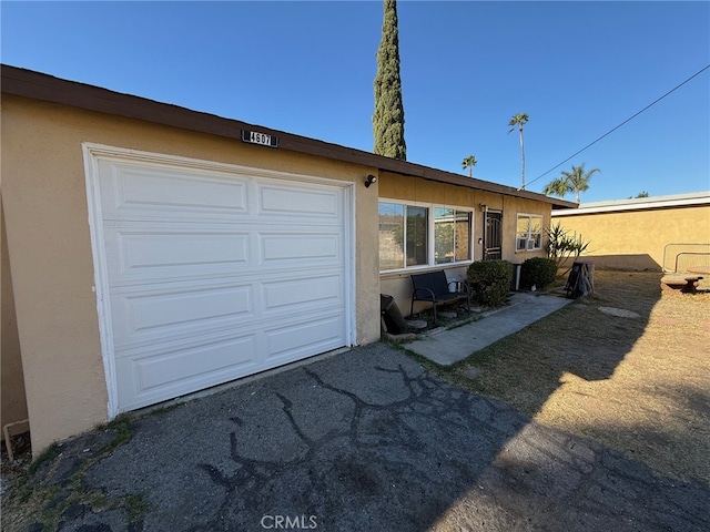exterior space featuring aphalt driveway and stucco siding