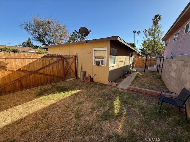exterior space with a fenced backyard, stucco siding, a gate, a gazebo, and a yard