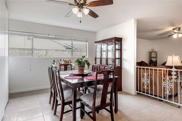 dining space featuring tile patterned flooring, ceiling fan, and baseboards