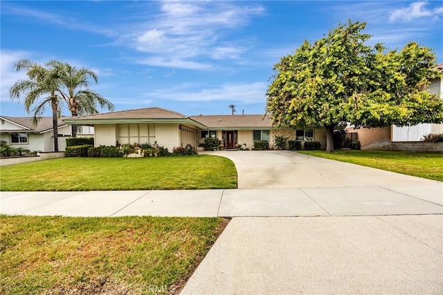 ranch-style house featuring a garage, a front lawn, fence, and concrete driveway